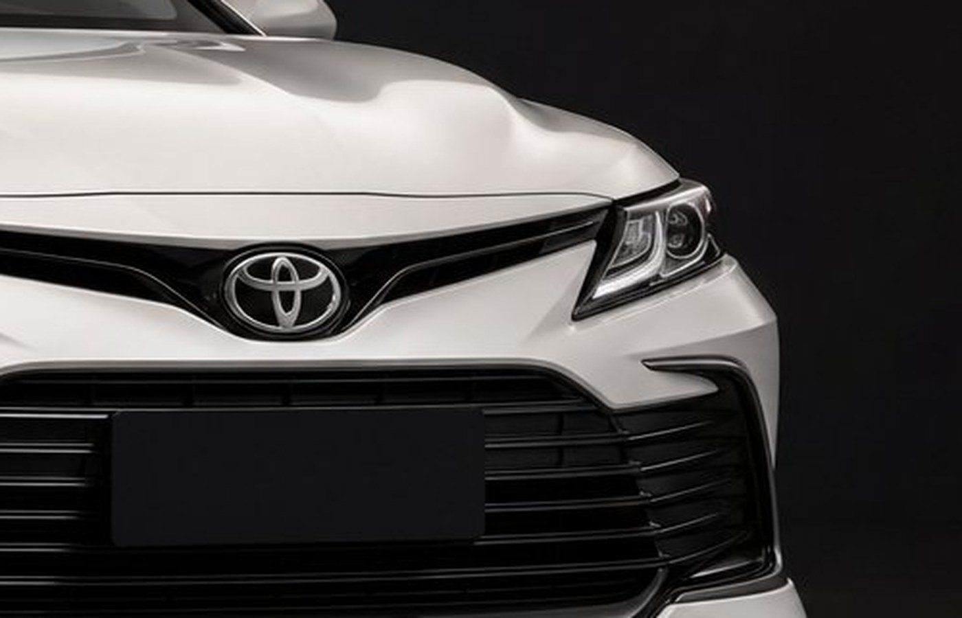 Close-up of a sedan headlight and grille